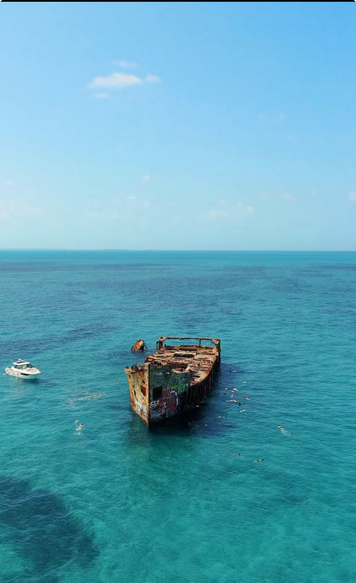 Snorkelers around a graffiti-covered wreck in Bimini