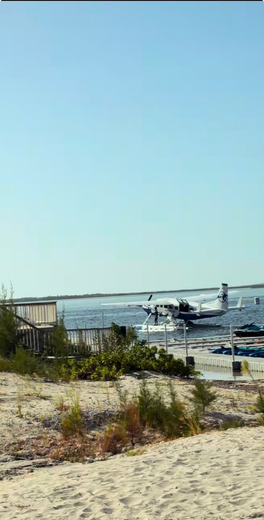 Seaplane at a Bimini dock with jet skis on the pier